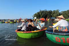 Turistas extranjeros disfrutan de la experiencia de navegar en pequeñas barcas de mimbre en el pueblo de cocoteros de Cam Thanh, una de las 50 aldeas más bellas del mundo en 2025. (Foto: VNA)