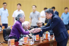 El primer ministro Le Minh Hung saluda a los militantes mayores. (Foto: VNA)