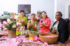 Los turistas experimentan la artesanía tradicional de infusionar té con flores de loto de Quang An. (Foto: VNA)