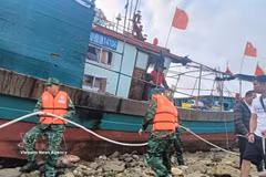 Oficiales y soldados de la Guardia Fronteriza de Hai Phong ayudan a un pesquero chino a asegurar sus amarras mientras esperan condiciones climáticas favorables para ser remolcado al puerto. (Foto: VNA)