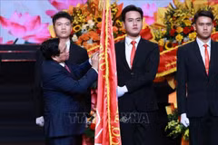 El primer ministro Pham Minh Chinh coloca la Orden Ho Chi Minh en la bandera tradicional de la VOV (Foto: VNA)