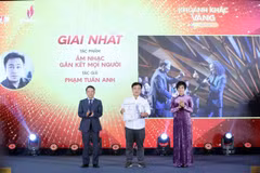 La directora general de la VNA, Vu Viet Trang (derecha), y el vicepresidente permanente de la Asociación de Periodistas de Vietnam, Nguyen Duc Loi (izquierda), entregan el primer premio a Pham Tuan Anh en el evento. (Foto: VNA)