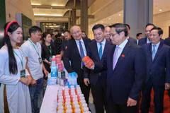 El primer ministro de Vietnam, Pham Minh Chinh, visita el stand del grupo TH al margen de la ceremonia de anuncio de productos que reciben reconocimiento de Marca Nacional. (Foto: Vietnam+)