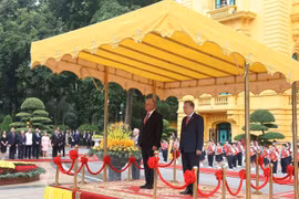 El secretario general To Lam y Díaz-Canel en la tribuna de honor, escuchando las bandas militares interpretar los himnos nacionales de Vietnam y Cuba. Foto: VNA