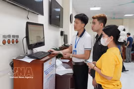 Funcionarios del Centro de Servicios Administrativos Públicos del barrio de Vinh Yen guían a los residentes en el proceso de registro matrimonial en línea a través del portal de servicios públicos. (Foto: VNA)