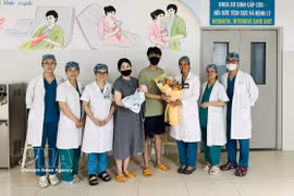 El personal médico del Hospital de Obstetricia y Pediatría de Da Nang entrega flores para felicitar a los padres y al bebé al momento del alta hospitalaria. (Foto: VNA)