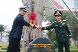 El ministro de Defensa de Vietnam, general Phan Van Giang, y su homólogo chino, coronel general Dong Jun, plantan un árbol en el puesto fronterizo internacional de Huu Nghi. (Foto: VNA)