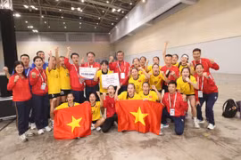 Las jugadoras y el cuerpo técnico de la selección femenina vietnamita de balonmano celebran su medalla de oro. (Foto: VNA)