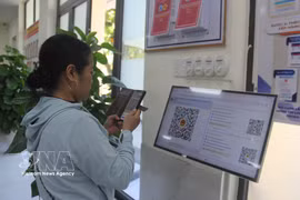 Una ciudadana escanea el código QR para obtener el turno en el Centro de Servicios Administrativos Públicos del barrio de Hoa Xuan, Da Nang. (Foto. VNA)