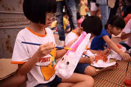Interesados niños en elaborar máscaras para Festival del Medio Otoño