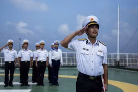 Soldados vietnamitas en plataforma DK1 saludan a la bandera nacional