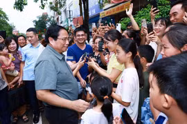 El primer ministro Pham Minh Chinh con los residentes del proyecto de vivienda social Thong Nhat. (Foto: VNA)