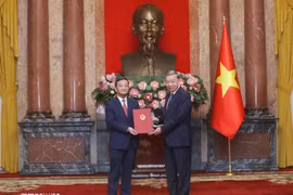 El secretario general del Comité Central del Partido Comunista de Vietnam (PCV) y presidente del Estado, To Lam, entrega la decisión de nombramiento al embajador vietnamita en Laos, Nguyen Minh Tam. (Foto: VNA)
