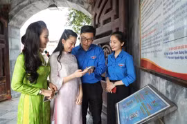 Jóvenes guían a los turistas para que escaneen códigos QR y aprendan sobre el sitio histórico de la Victoria de Xuong Giang. (Foto: VNA)