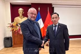 El secretario del Comité Central del PCV y jefe de su Comisión de Relaciones Exteriores, Le Hoai Trung (derecha), se reúne con el secretario nacional de relaciones internacionales del PS, Dylan Boutiflat. (Foto: VNA)