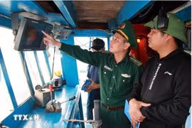 Un oficial de la guardia fronteriza revisa los dispositivos de vigilancia en un barco pesquero (Foto: VNA)