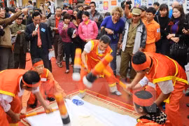 La competencia de preparar pastel de arroz glutinoso en forma redonda atrae gran atención del público (Fuente:VNA)