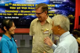 El astrofísico y cosmólogo estadounidense ganador del Premio Nobel de Física en 2006 George Fitzgerald Smoot y una estudiante vietnamita (Fuente: VNA)