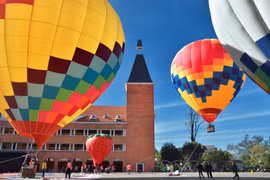 Contemplan globos aerostáticos en cielo de ciudad montañosa de Vietnam 