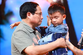 El primer ministro Pham Minh Chinh alentó a Nguyen Quoc Bao, quien perdió a su padre y su hermana mayor por las inundaciones en la comuna de Yen Thuan, distrito de Ham Yen, provincia de Tuyen. Quang. (Fuente:VNA)