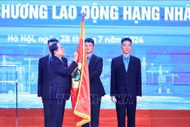 El presidente de la Asamblea Nacional, Tran Thanh Man, coloca la Orden del Trabajo de primera clase en la bandera tradicional de la Confederación General del Trabajo de Vietnam. (Fuente: VNA)