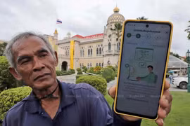 Un jardinero tailandés muestra un mensaje en su teléfono en respuesta a su registro en el sistema de billetera digital. (Foto: bangkokpost.com)