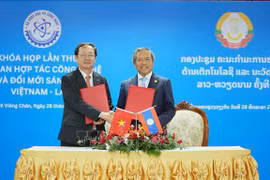 Los dos ministros intercambian documentos de la primera reunión del Comité de cooperación en Tecnología e Innovación Vietnam – Laos. (Fuente: VNA)