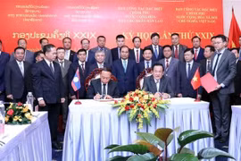 El viceministro de Defensa y jefe del grupo de trabajo vietnamita, el teniente general Vo Minh Luong (derecha), y el viceministro de Defensa y jefe del grupo de trabajo de Laos, el teniente general Thongloi Silivong, firman el acta de la reunión. (Foto: VNA)