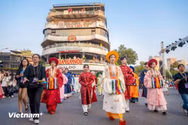 Cientos de personas vestidas con trajes antiguos desfilan por las principales calles de Hanoi 
