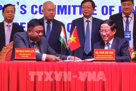 Representantes del Comité Popular de la provincia Binh Dinh y el Consulado General de la India en Ciudad Ho Chi Minh firman un memorando de entendimiento en la conferencia. (Foto: VNA)