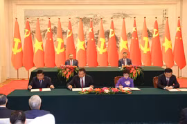 Ceremonia de firma del Acuerdo de Cooperación entre la Agencia Vietnamita de Noticias d y la Agencia de Noticias Xinhua (derecha) y la cooperación en materia de inversiones (izquierda) entre los dos países. (Fuente: VNA)