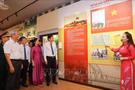 A los visitantes se les informa sobre las fotografías expuestas en la exposición. (Foto: VNA)