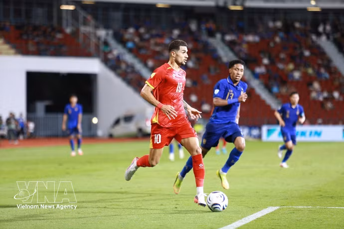 Hoang Hen de Vietnam (n.º 10) intenta avanzar con el balón ante un jugador tailandés.