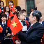 El presidente de la Asamblea Nacional, Tran Thanh Man, con niños y miembros de la comunidad vietnamita en China. Foto: