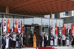 El presidente surcoreano, Lee Jae Myung, y su esposa, junto con el secretario general To Lam y su cónyuge, en posición de honor, escuchan a la banda militar interpretar los himnos nacionales de ambos países. Foto: VNA
