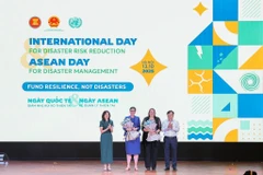 Nguyen Hoang Hiep, Viceministro de Agricultura y Medio Ambiente, y Pauline Tamesis, Coordinadora Residente de la ONU en Vietnam, entregaron flores en reconocimiento a la OMS y la OIM como miembros de la alianza. Foto: VNA