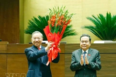 El presidente de la Asamblea Nacional, Tran Thanh Man (derecha), entrega flores para felicitar al secretario general del Partido y presidente del Estado, To Lam. (Foto: VNA)