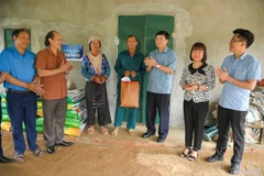 El presidente del Comité del Frente de la Patria de Vietnam de la provincia de Dien Bien, Mua A Vang, entrega regalos a una familia que recibe apoyo para construir una casa en la comuna de Pu Nhi. Foto: mattran.org.vn