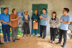 El presidente del Comité del Frente de la Patria de Vietnam de la provincia de Dien Bien, Mua A Vang, entrega regalos a una familia que recibe apoyo para construir una casa en la comuna de Pu Nhi. Foto: mattran.org.vn