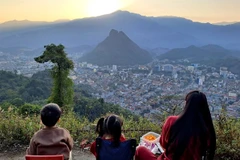 Turistas ven la puesta de sol sobre la ciudad de Hà Giang desde la montaña Mỏ Neo.— Foto: VNA
