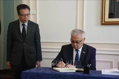Bair Zhamsuyev, vicepresidente del Comité de Asuntos Exteriores del Consejo de la Federación de la Asamblea Federal de Rusia, escribe en el libro de condolencias durante la ceremonia celebrada por la Embajada de Vietnam en Rusia. (Foto: VNA)