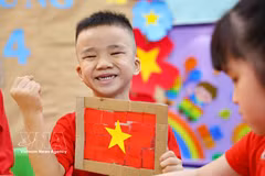 Niños vietnamitas entusiastas con la creación de la bandera nacional 