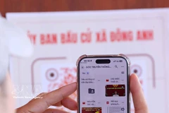 Los votantes escanean códigos QR con sus teléfonos inteligentes para consultar rápidamente información relacionada con sus derechos de voto. Foto: Van Diep – VNA