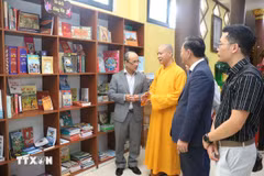El abad de la Pagoda Phat Tich en Vientiane presenta la estantería. (Foto: VNA)
