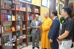 El abad de la Pagoda Phat Tich en Vientiane presenta la estantería. (Foto: VNA)