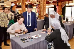 Nguyen Thi Thanh Nga, esposa del presidente del Parlamento de Vietnam y Rozana bintin Kamal, esposa del presidente de la Cámara de Representantes de Malasia, experimentan la impresión tradicional de telas. Foto: VNA