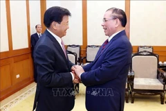 El secretario general del PPRL y presidente de ese país, Thongloun Sisoulith, sostiene un encuentro con el exsecretario general del PCV, Nong Duc Manh (Fuente: VNA)