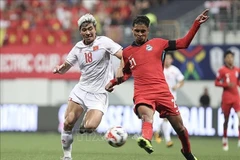 El futbolista Thanh Binh (camiseta blanco) fue bloqueado ferozmente por un defensor de Singapur en el partido de ida de la semifinal de la Copa de la ASEAN el 26 de diciembre. (Foto: VNA)