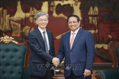 El primer ministro Pham Minh Chinh (derecha) y Kenji Okamura, subdirector gerente del Fondo Monetario Internacional (Fuente: VNA)