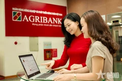 Empleados del Banco de Desarrollo Agrícola y Rural de Vietnam (Agribank) orientan a sus clientes sobre cómo realizar transacciones seguras en canales digitales. Foto: qdnd.vn